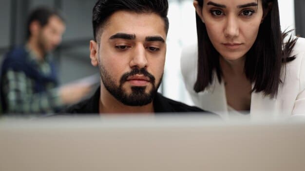 A close-up of an employee's face looking concerned as they examine a suspicious email on their computer screen during a cybersecurity training exercise. The focus is on the employee's reaction and the critical thinking involved in identifying a potential threat.