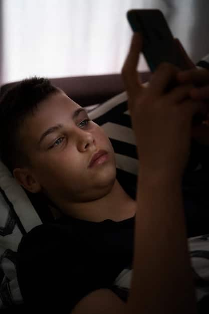 Close-up of a person's hand compulsively scrolling through social media on their phone, with a sense of anxiety and restlessness visible in their expression. The background is out of focus.