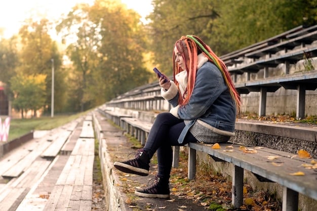 A person sitting alone on a park bench, looking at their phone with a sad expression. The background is blurred, emphasizing the person's isolation. The phone screen glows brightly, contrasting with the drab surroundings.