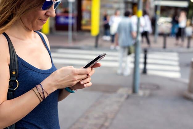 A person using their smartphone in a busy public place, with blurred figures in the background. The focus is on the smartphone screen, which displays a warning message about unsecured Wi-Fi.