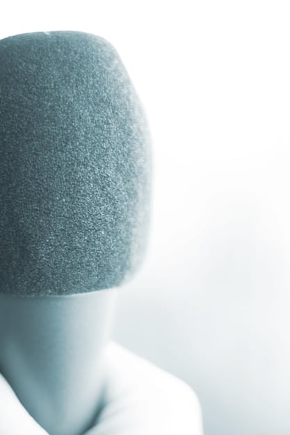 A person holding a high-quality binaural microphone close to their mouth, softly whispering, with a clean and minimalistic background, showcasing the focus on sound in ASMR production.